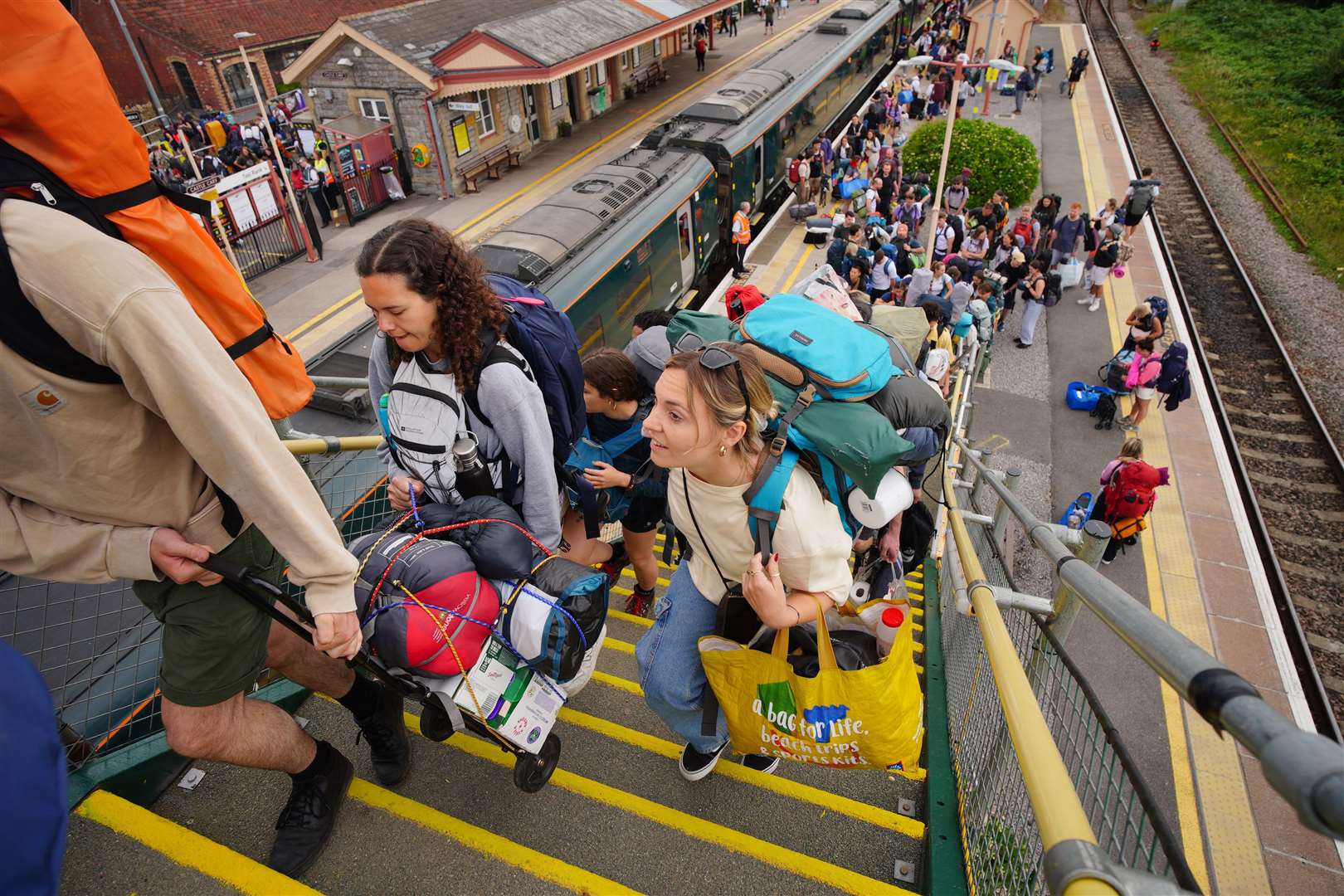 Glastonbury revellers are arriving in their hundreds at Castle Cary train station (Ben Birchall/PA)