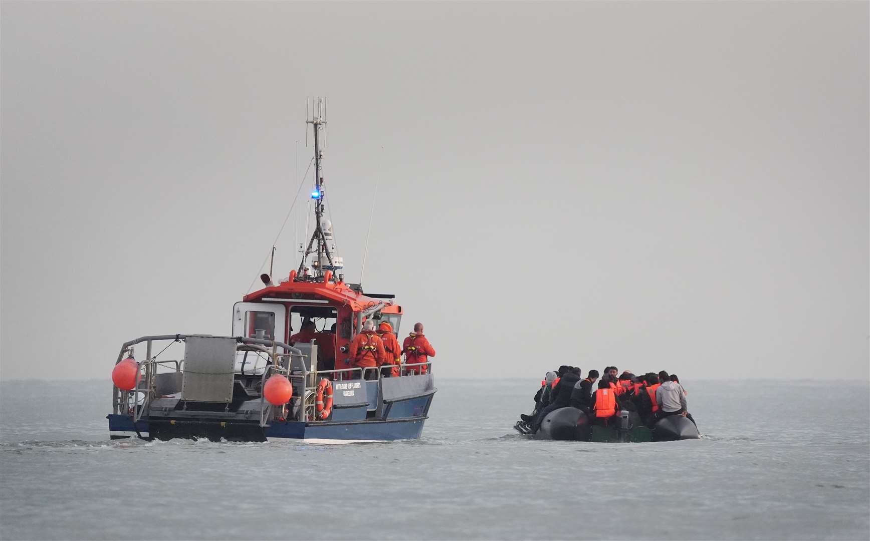 French authorities escort people thought to be migrants on board a small boat leaving the beach at Gravelines (Gareth Fuller/PA)