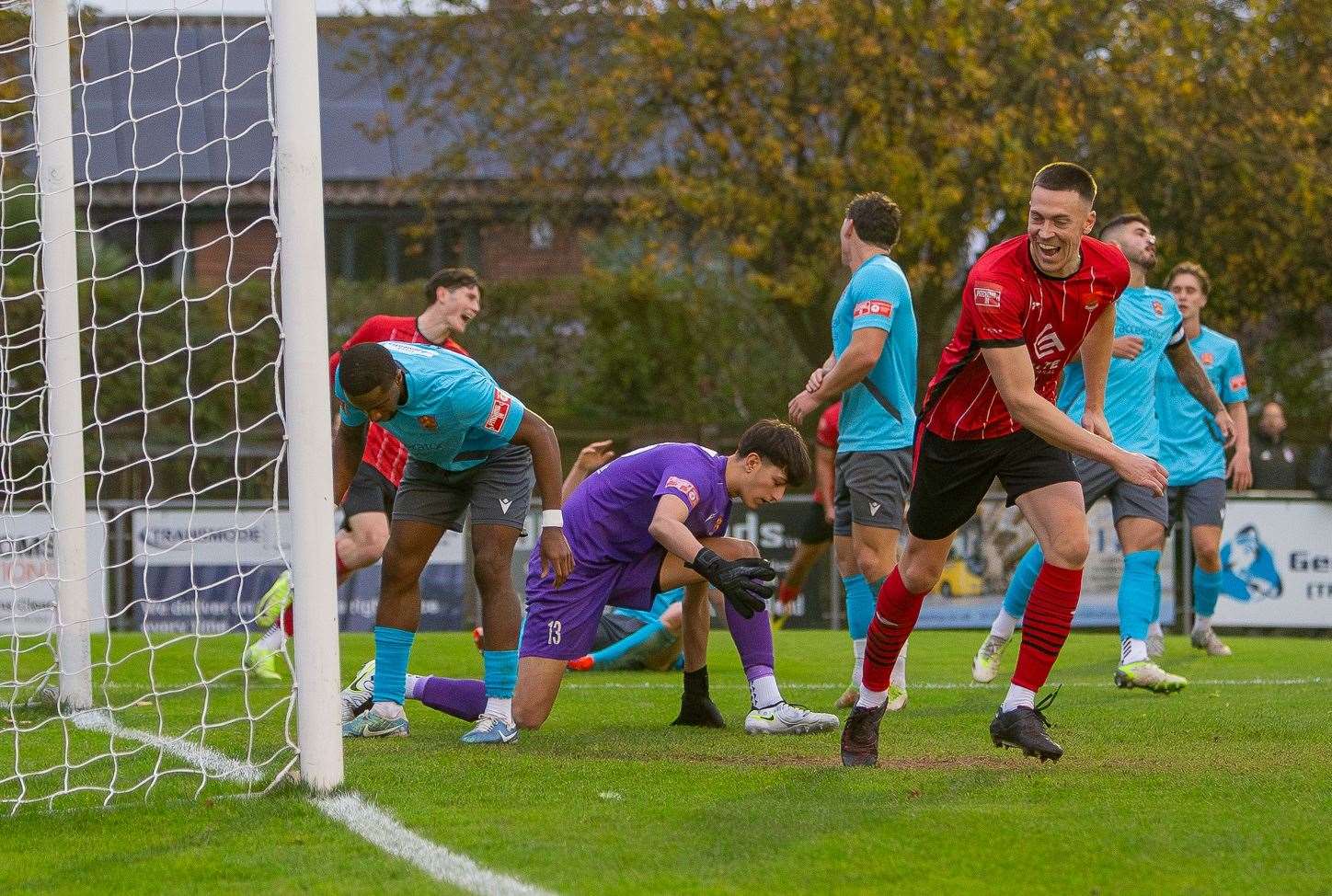 Felixstowe & Walton United's Josh Mayhew (red) wheels away after Cambridge City No.2 Giani Ashley gives the hosts the lead with an own goal Picture: Stefan Peck