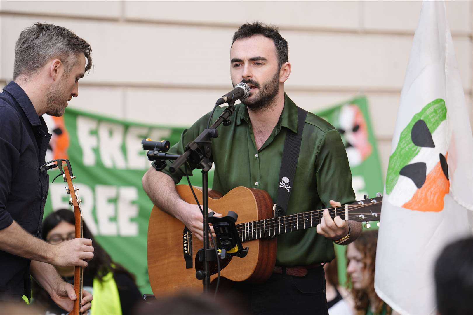 A guitarist performs among supporters of Kneecap’s Liam Og O Hannaidh outside Westminster Magistrates’ Court in London (Jordan Pettitt/PA)