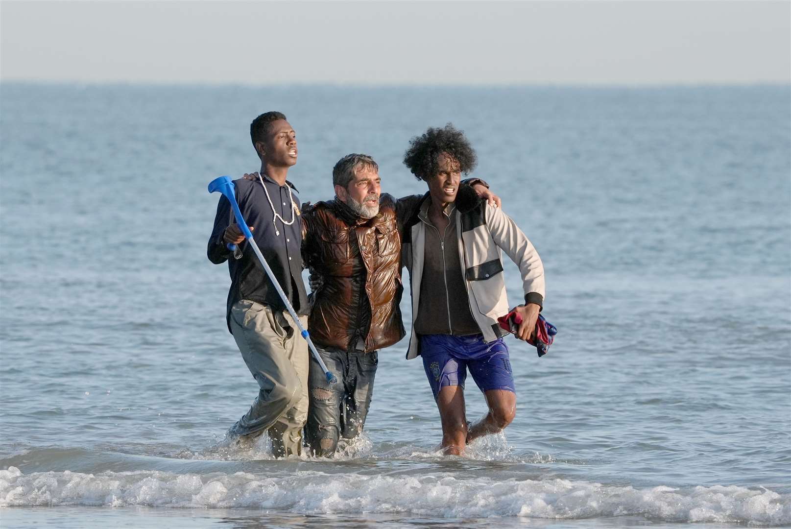 People thought to be migrants wade through the sea to board a small boat leaving the beach at Gravelines, France, in an attempt to reach the UK by crossing the English Channel (Gareth Fuller/PA)