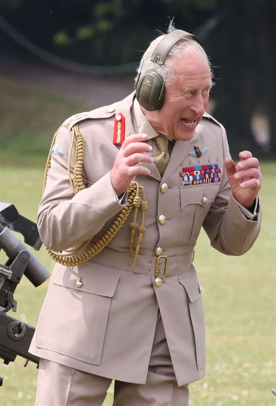 Charles reacts after firing an artillery piece during his visit (Richard Pohle/The Times/PA)