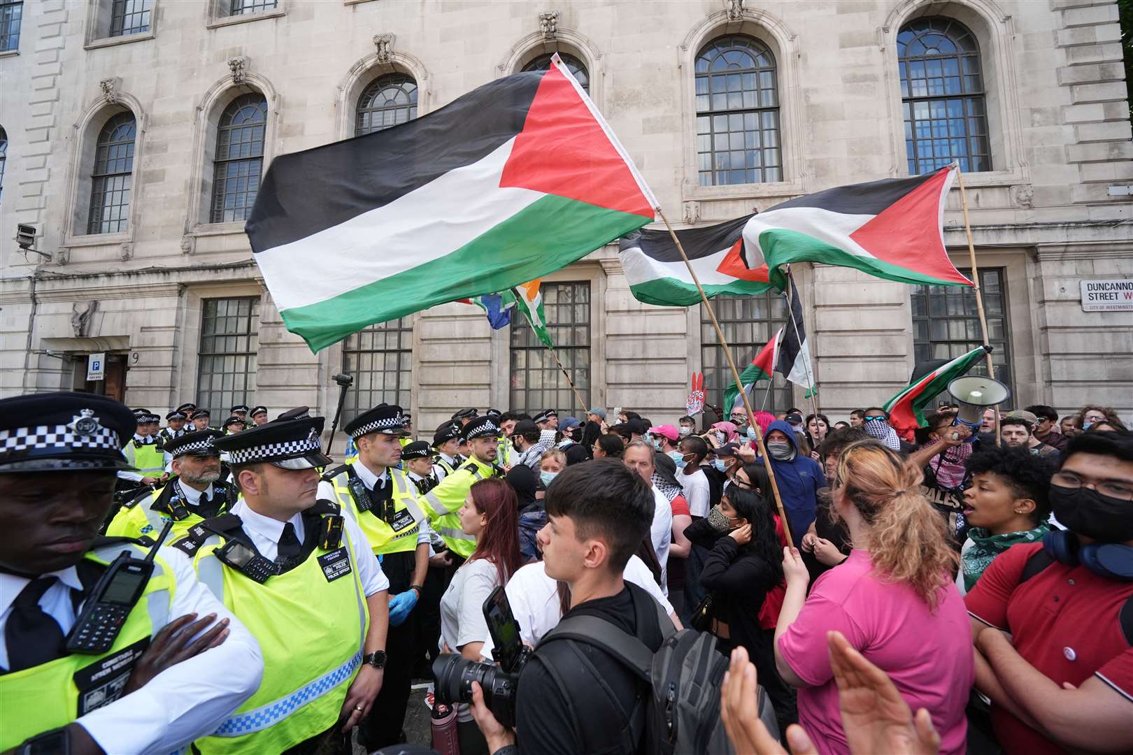 Police block the way of people taking part in a demonstration in central in London (PA)