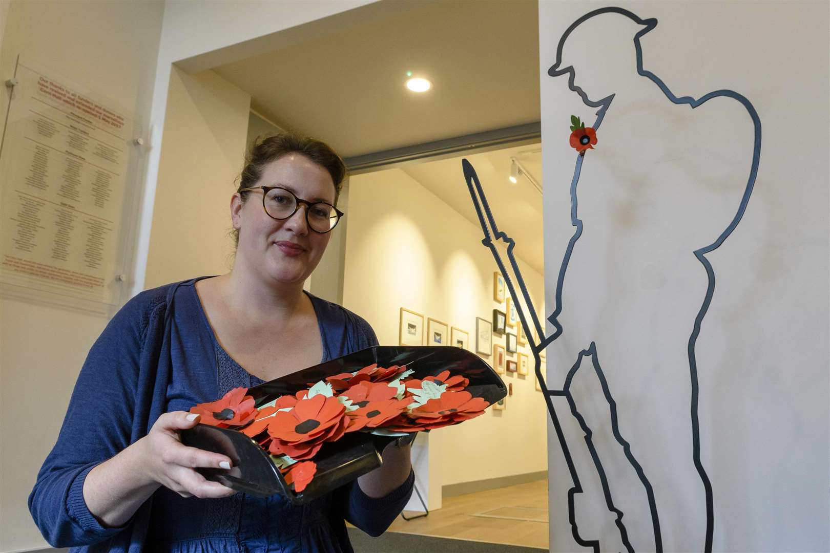 Sophie Towne, arts and heritage outreach manager at the Corn Hall with some of the poppies made to be part of an art installation around the figure. Picture: Mark Bullimore Photography