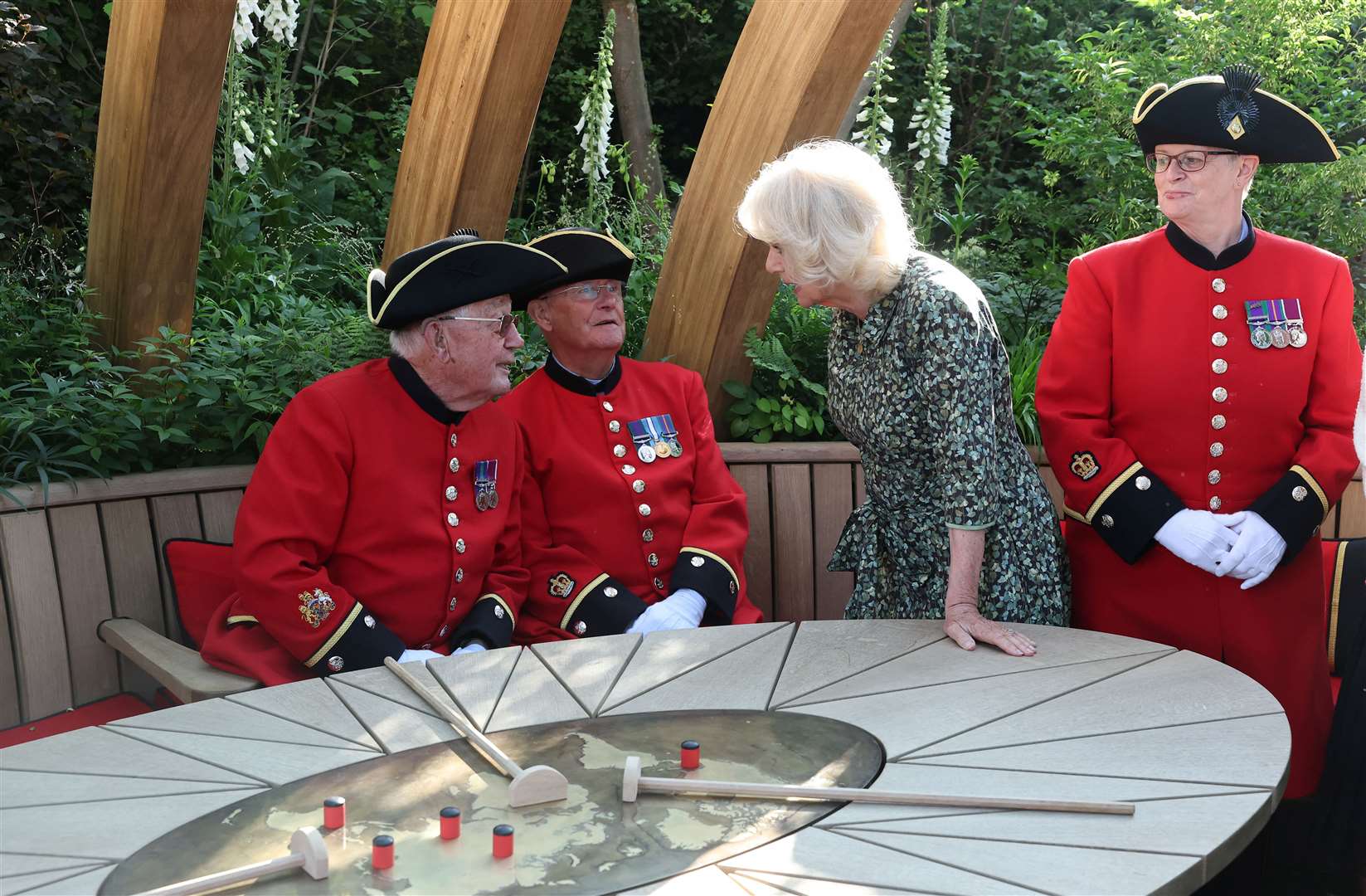 The Queen speaks with Chelsea Pensioners at the London Square Chelsea Pensioners Garden (Toby Melville/PA)