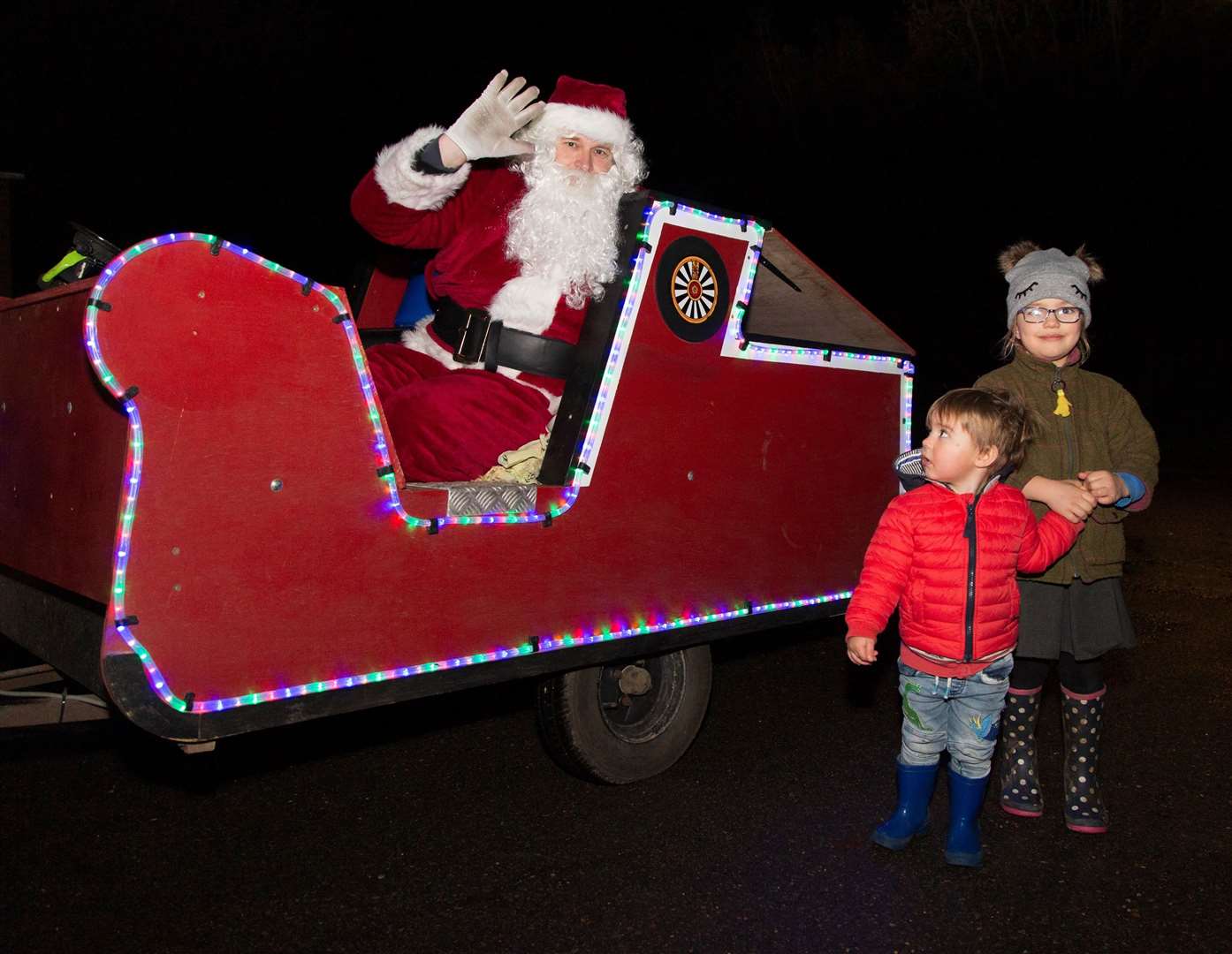 Santa stops to wave at children along the route.