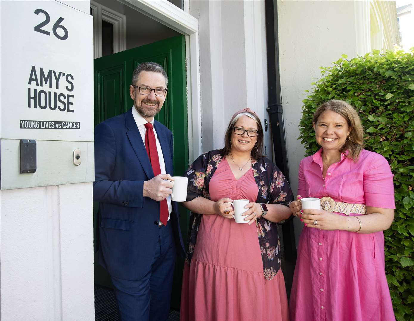 Malcolm Fleming, director of public affairs, People’s Postcode Lottery; Sian Mulholland MLA (centre), and Rachel Kirby-Rider, chief executive at Young Lives vs Cancer, at Amy’s House in Belfast (Brian Morrison/Smarts Agency/PA)