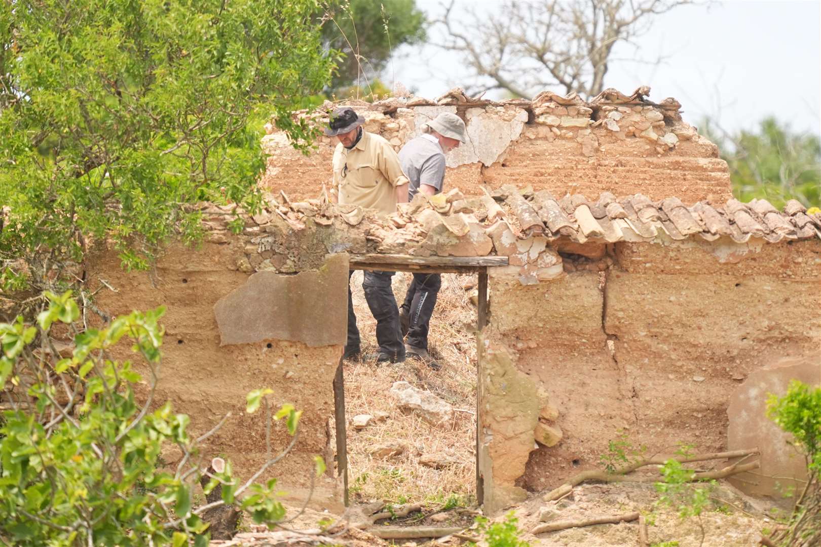 Search teams look through a derelict and abandoned property to the west of Praia da Luz (James Manning/PA)