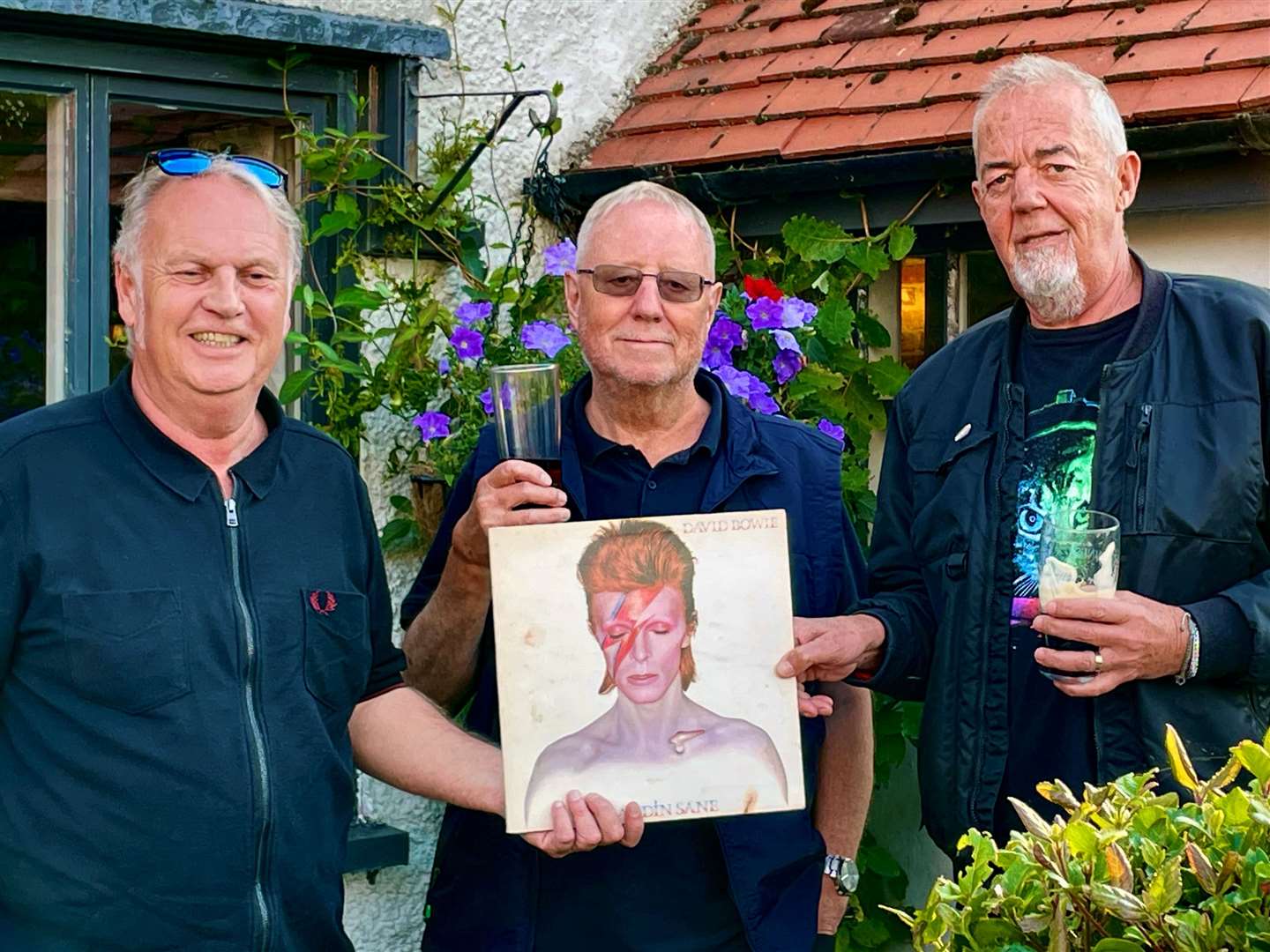 Duncan (left) reunites Steve (centre) with his long-lost David Bowie LP, watched by Duncan’s friend Matt.