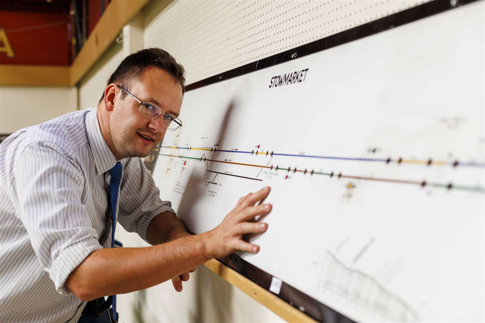 Auctioneer Dan Wood with a framed print of the Stowmarket line. Picture: Mark Bullimore Photography 2022.