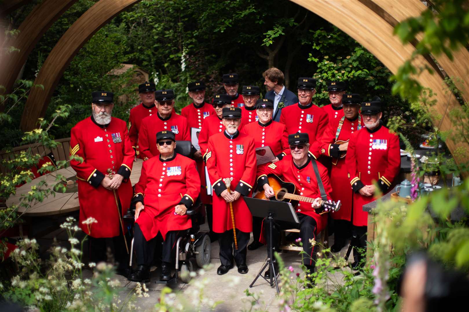 Chelsea Pensioners pose in one of the gardens (James Manning/PA)
